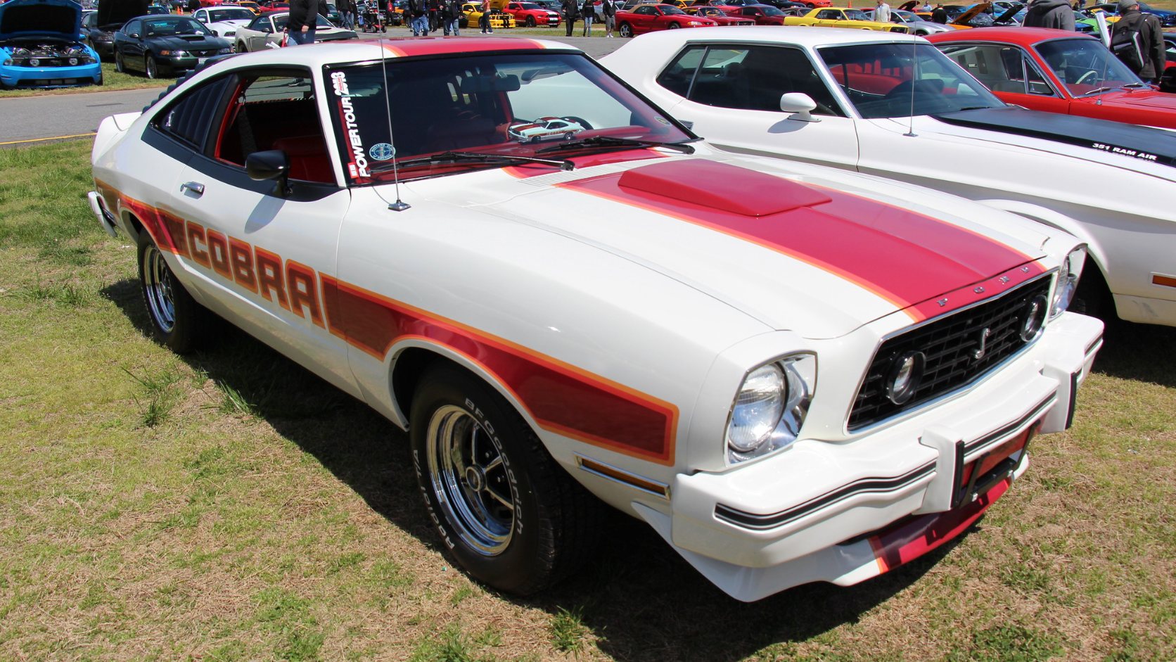 Polar White 1977 Ford Mustang II Cobra II hatchback with red stripes and Cobra lettering, front three-quarter view