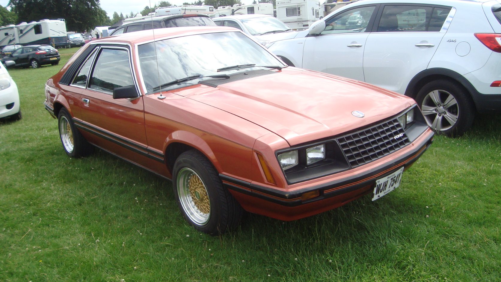 Copper 1982 Ford Mustang GL hatchback with gold wire-style wheels, front three-quarter view
